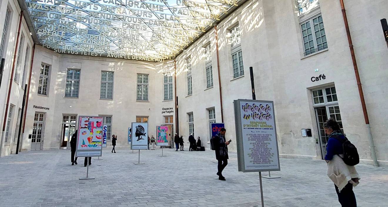photo de la Cité internationale de la langue française à Villers-Cotterêts sous une verrière avec seize affiches exposées et des visiteurs qui les regardent