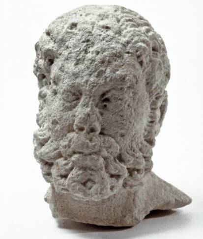 Vue rapprochée d'une tête barbue d'Hercule découverte dans le puits à dromos LX à Glanum.