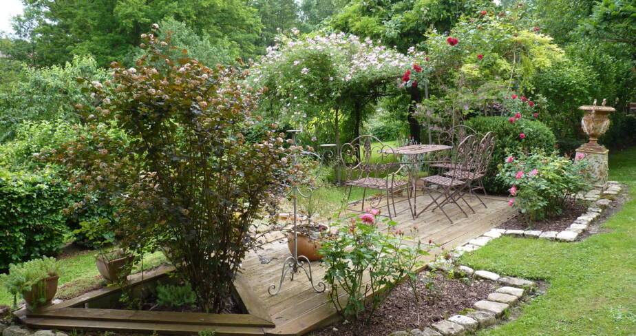 Table et chaises de jardin au milieu d'un bosquet