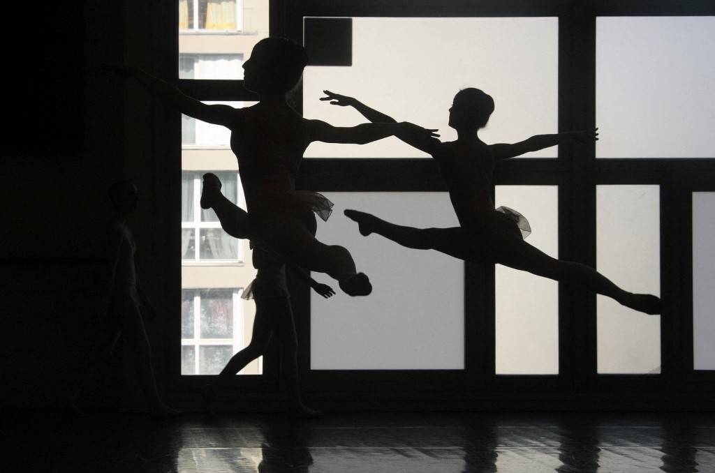 photo de danseurs classiques prise en contre jour dans un batiment moderne