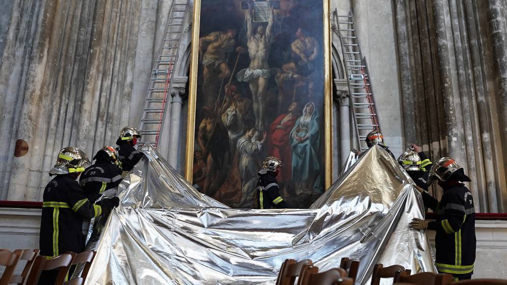 Des pompiers protègent une toile de la cathédrale