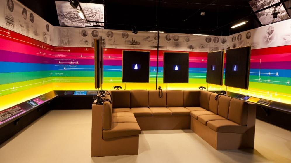 photo d'une salle du musée de la céramique de desvres avec un mur multicolore et des fauteuils