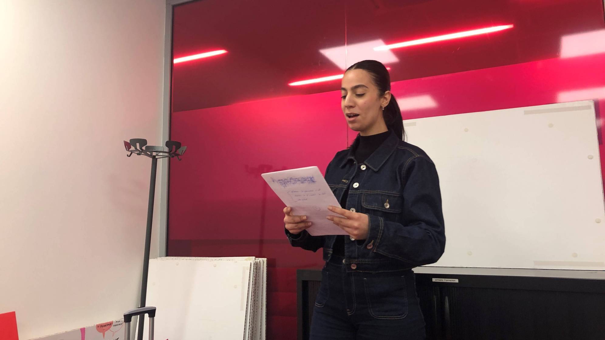 photo d'une jeune femme debout avec un papier à la main en train de parler