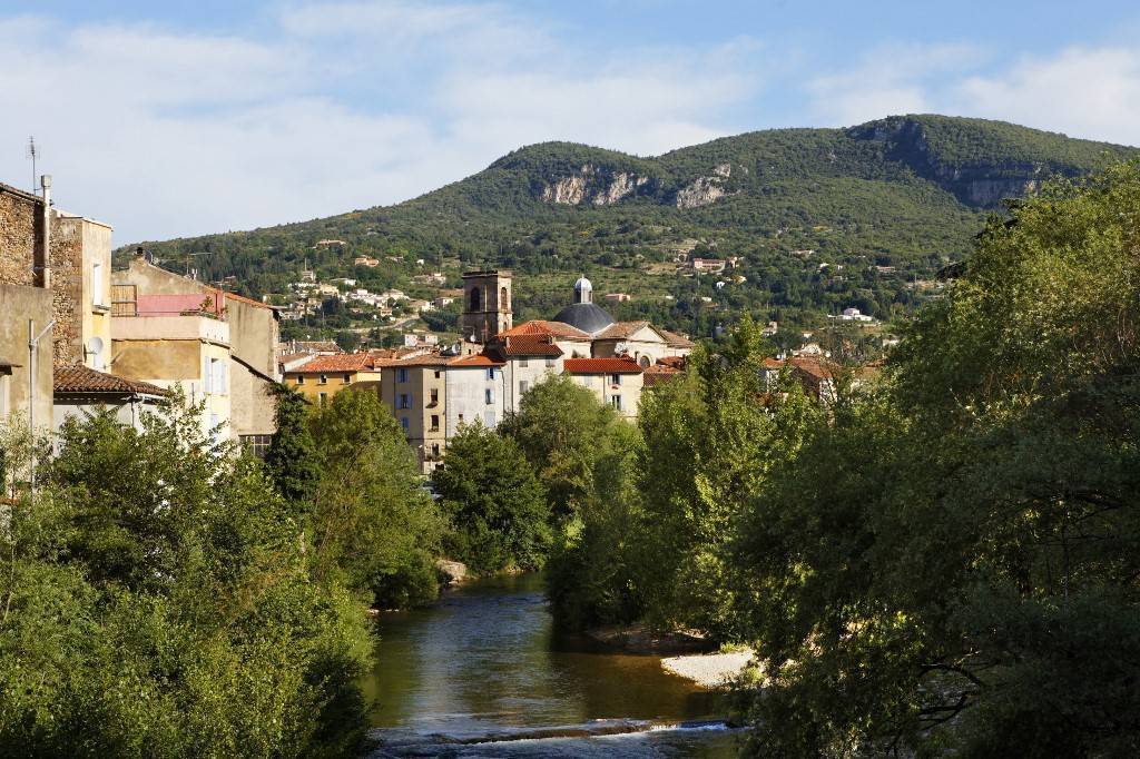 Photo prise à Lodève montrant au premier plan une rivière et au second la ville