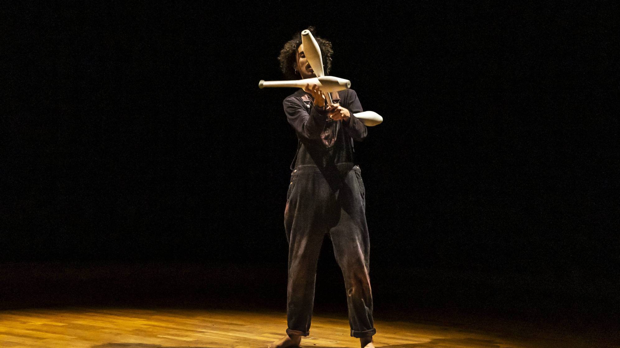 photo d'un homme sur une scène en train de faire du jonglage avec des quilles
