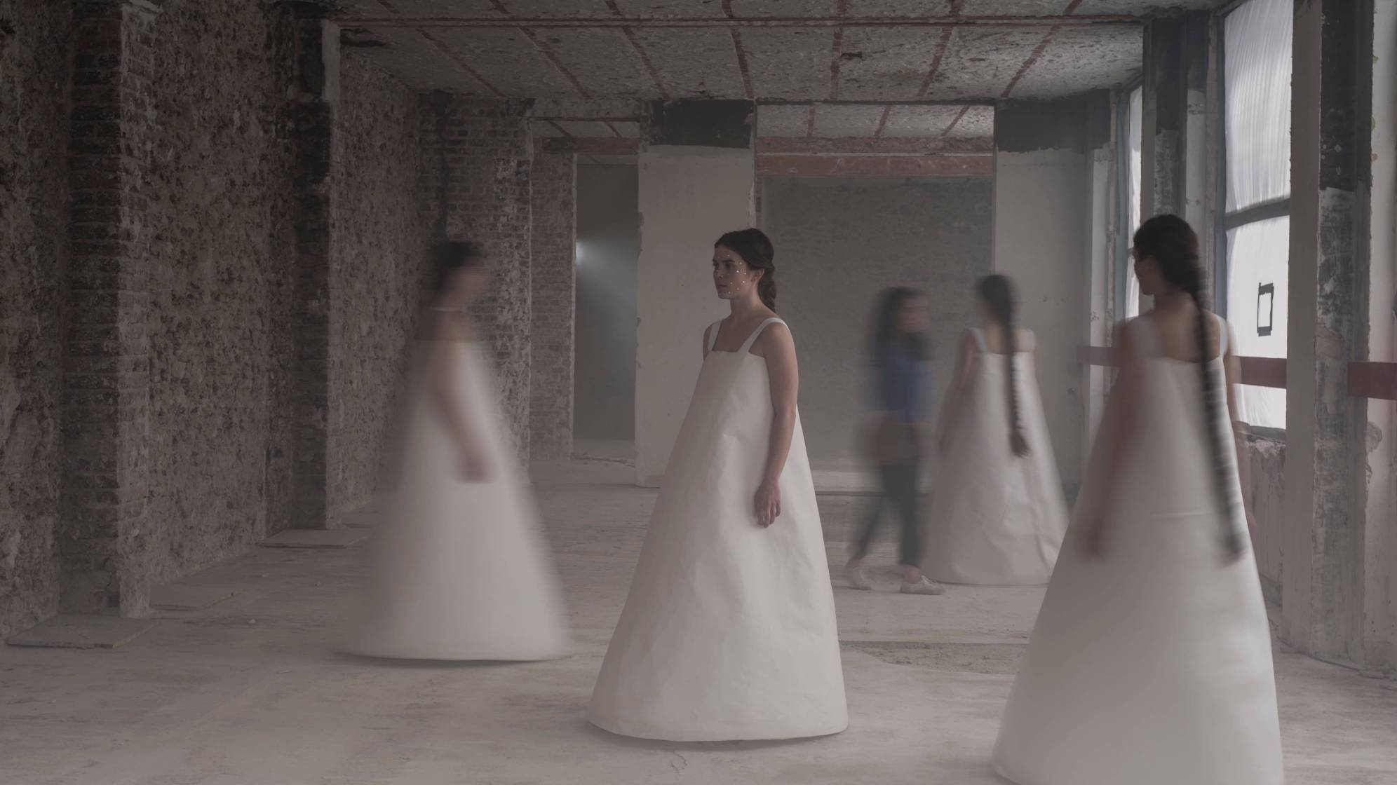 photo représentant 4 danseuses en robe blanche dans un décor industriel, image un peu floue
