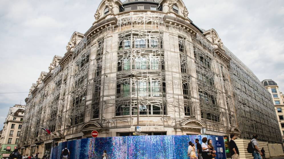 oeuvre_bleue_sur_palissade_devant_immeuble_rue_passants