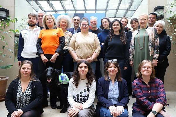 groupe de femems et d'hommes avec un chien dans le cadre handesign