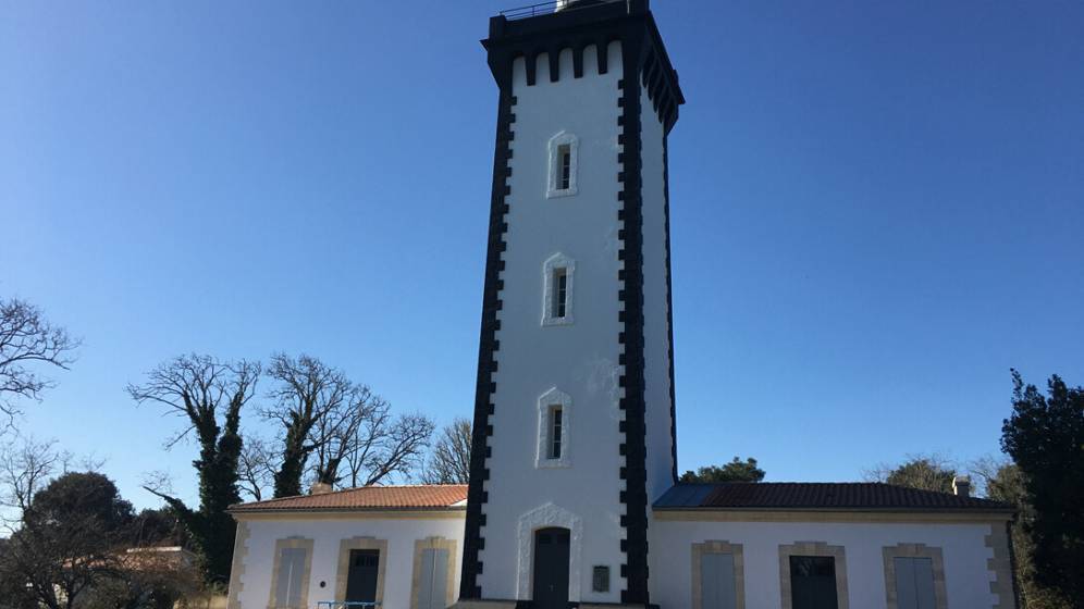 Photo extérieure du Phare de Grave, les ailes Nord et Sud fraichement reprises sont visibles de part et d'autre de la tour carrée du Phare