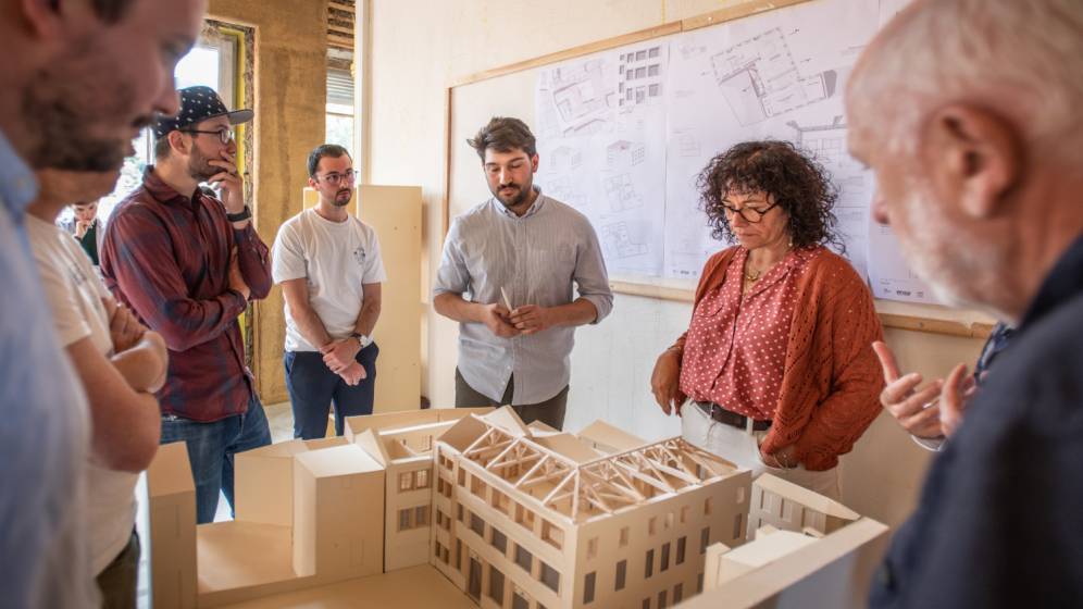 Un groupe de personnes rassemblées autour d'une maquette