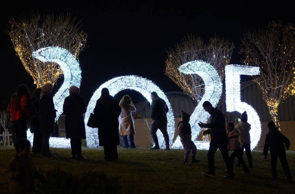 photo avec les chiffres 2025 écrit en lumière et des personnes devant