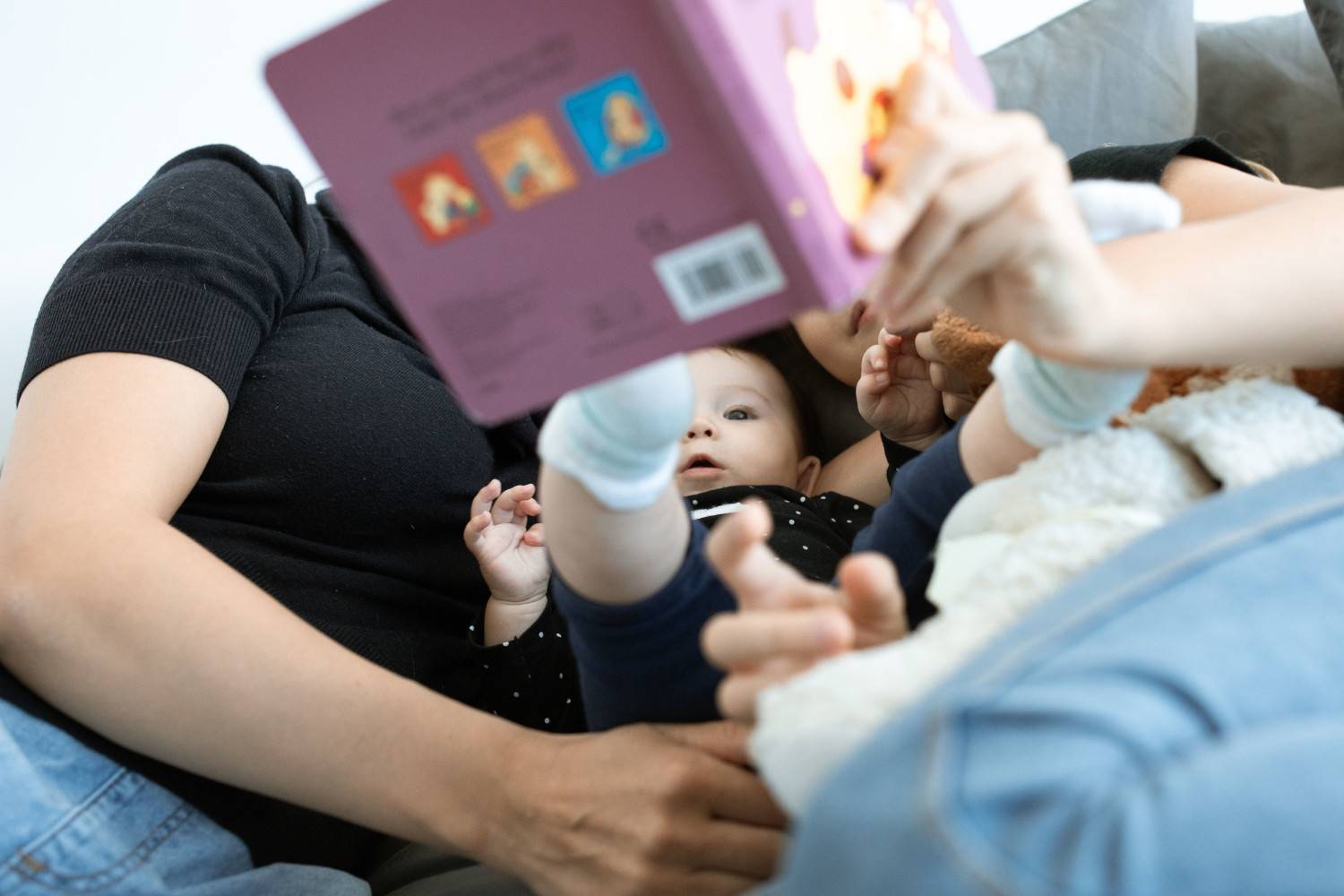 Un bébé et une famille lisent ensemble, promouvant l'amour et l'éducation. Cadre intérieur confortable.