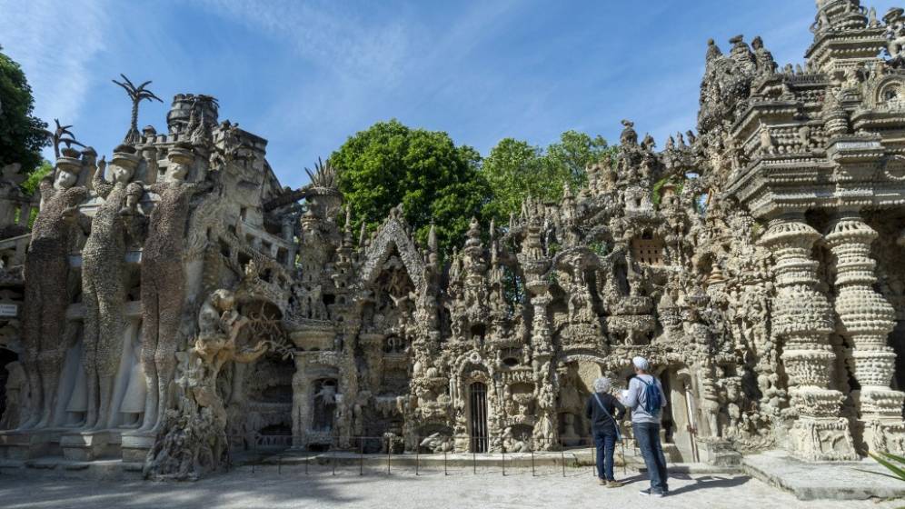 palais du facteur cheval avec deux visiteurs au premier plan