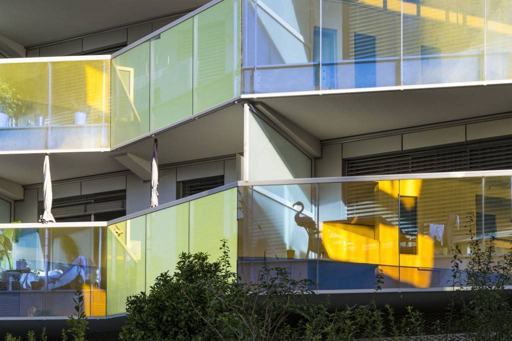 photo en gros plan de balcons d'un immeuble récent avec le reflet du soleil