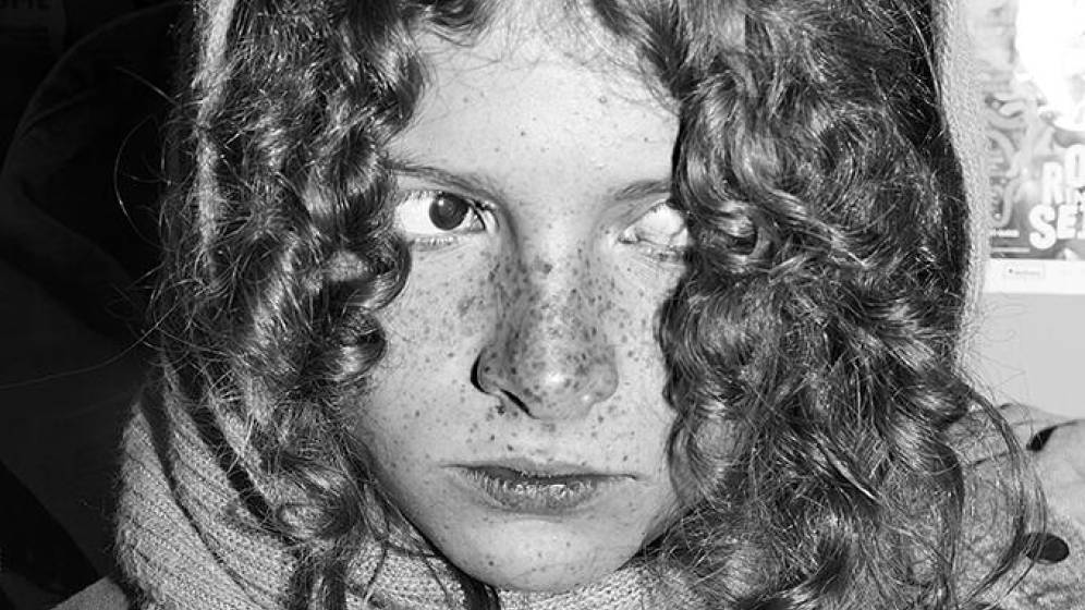 photographie du visage d'une jeune femme en noir et blanc.