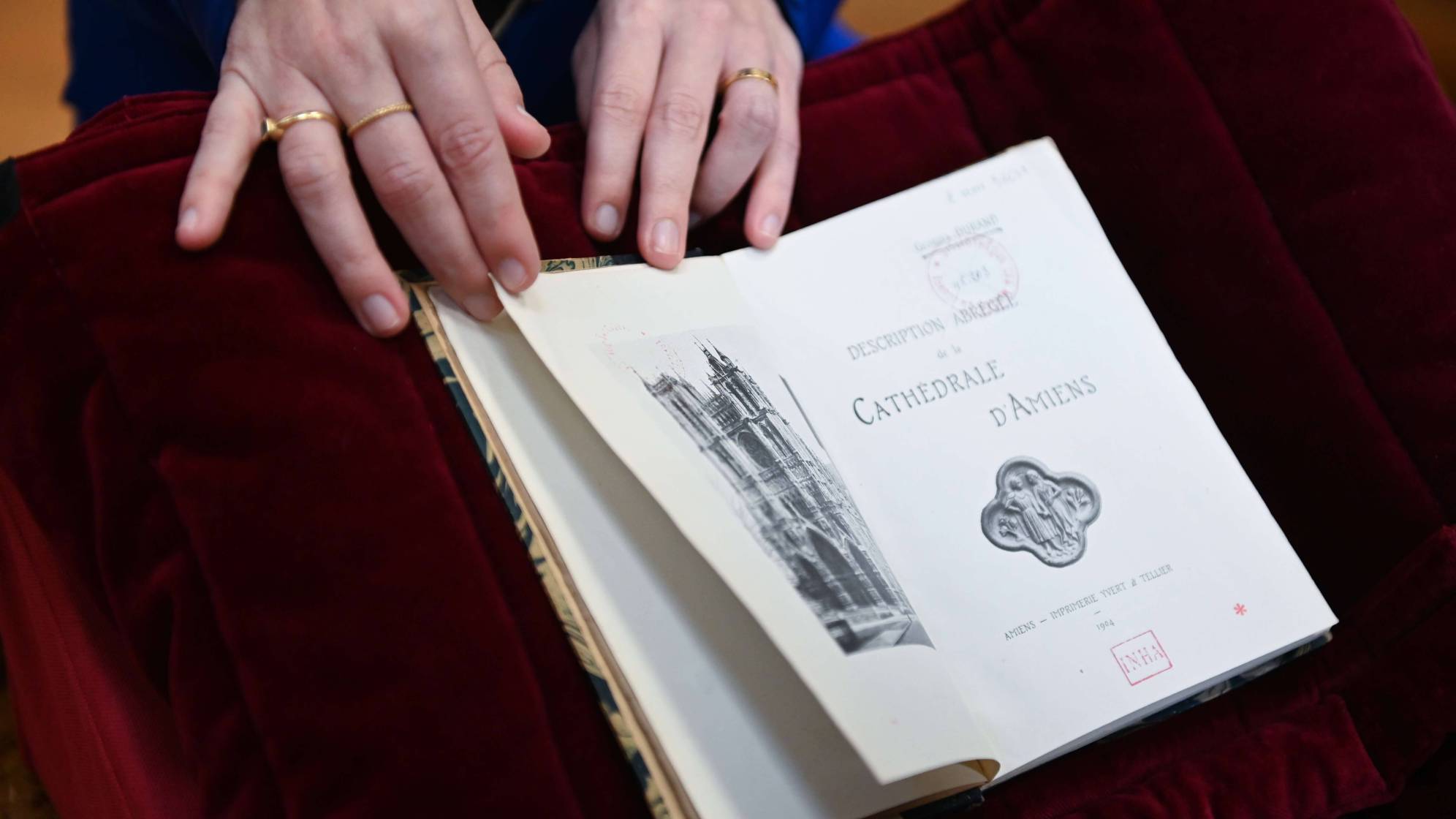 photo d'un livre ouvert avec une main qui le tient ouvert