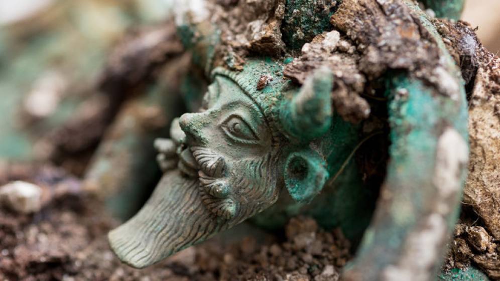 Anse d'un chaudron en bronze représentant la tête du dieu grec Acheloos provenant d'une tombe princière datée du début du Ve siècle avant notre ère, découverte dans un complexe funéraire monumental exceptionnel, mis au jour à Lavau (Aube), 2015. Vue aérienne d'un grand fossé ceinturant un tumulus princier Une  daté du début du Ve siècle avant notre ère, à Lavau (Aube), 2015 © Denis Gliksman, Inrap