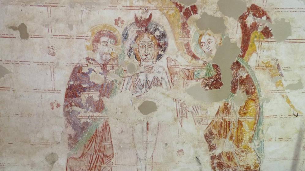 Cette peinture murale représentant le baptême du Christ date du XIIe siècle tandis que le décor ornemental de double faux joints rouge daté du XIIIe siècle
